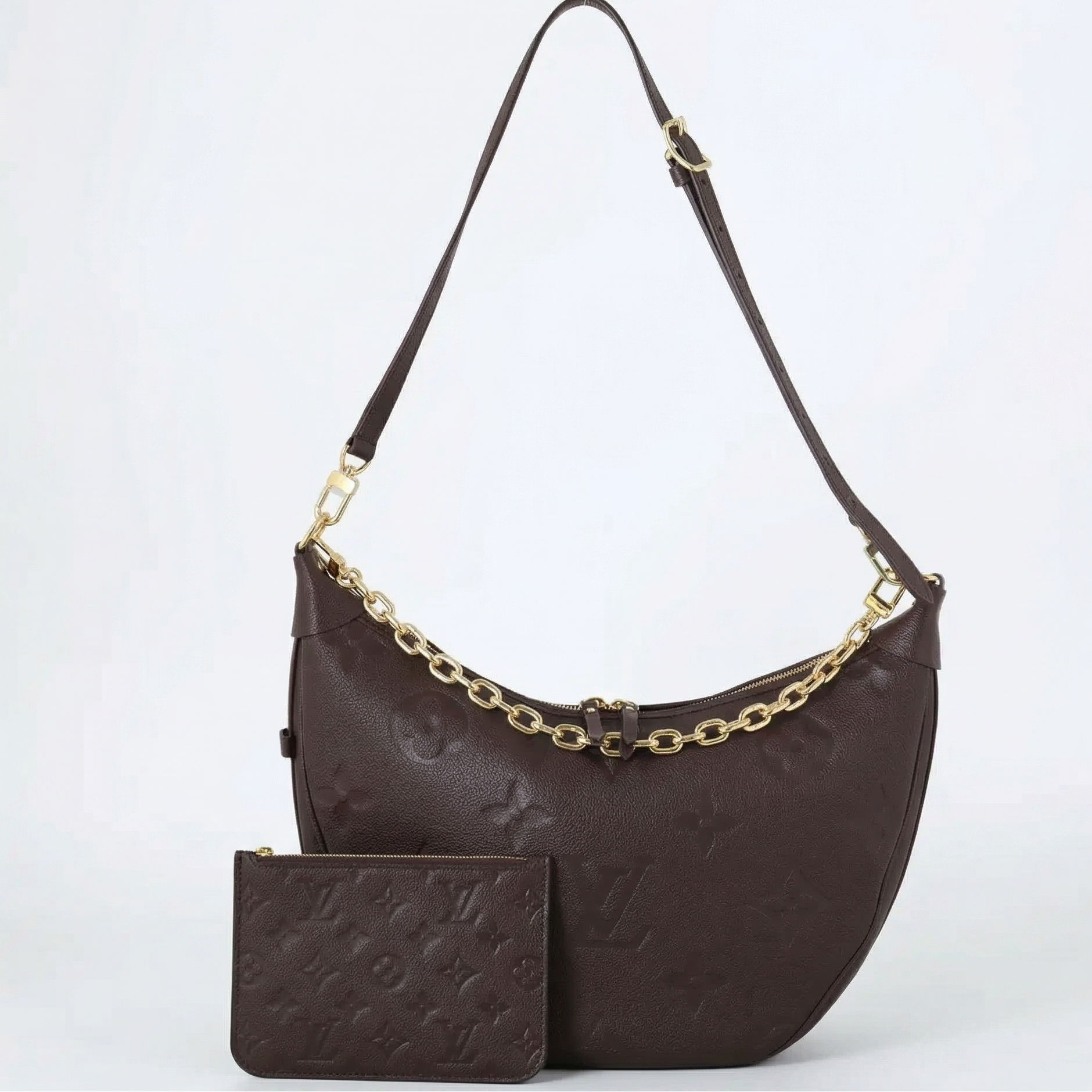 Black handbag with gold chain detail and matching pouch on a white background