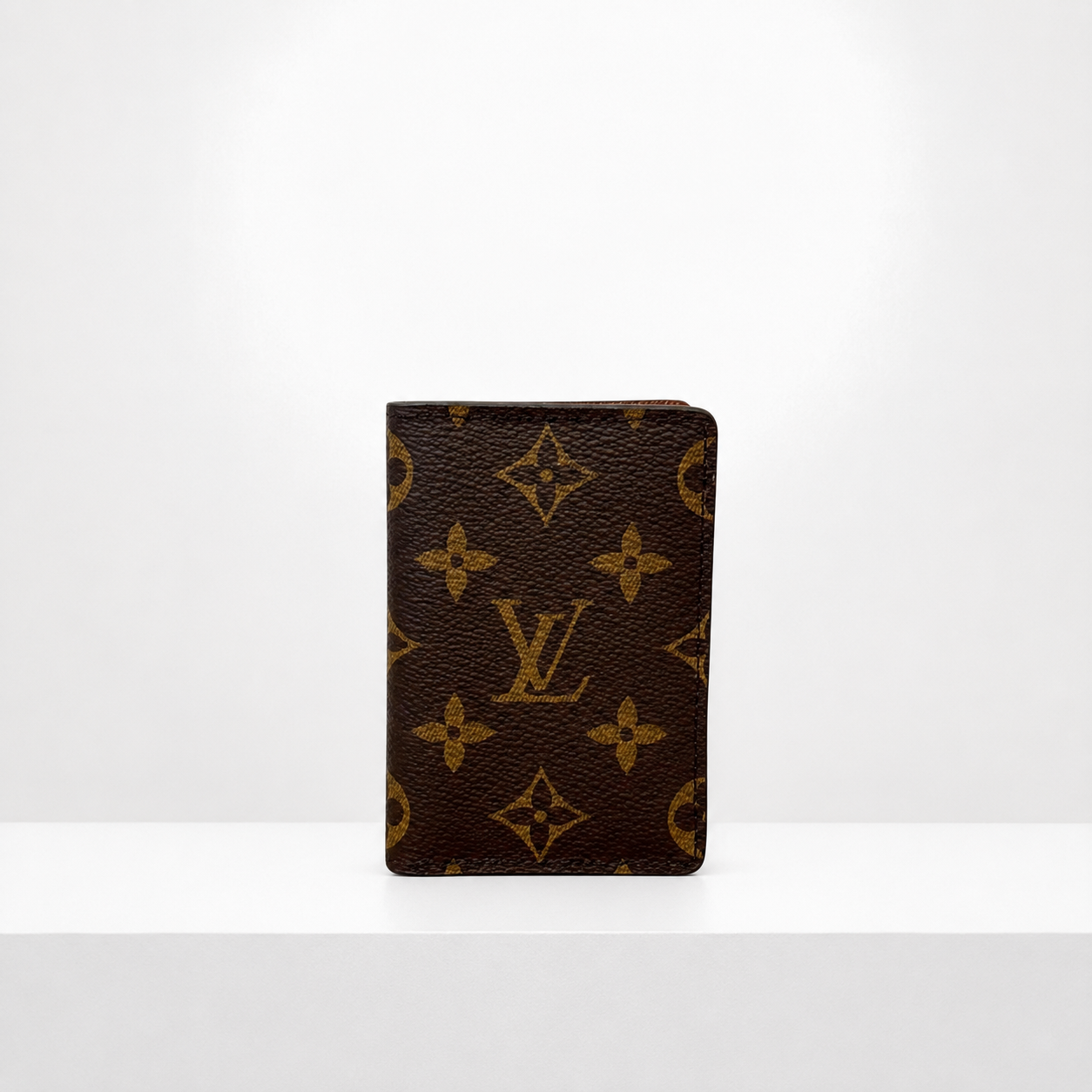 Brown small wallet standing upright on a white surface against a white background.