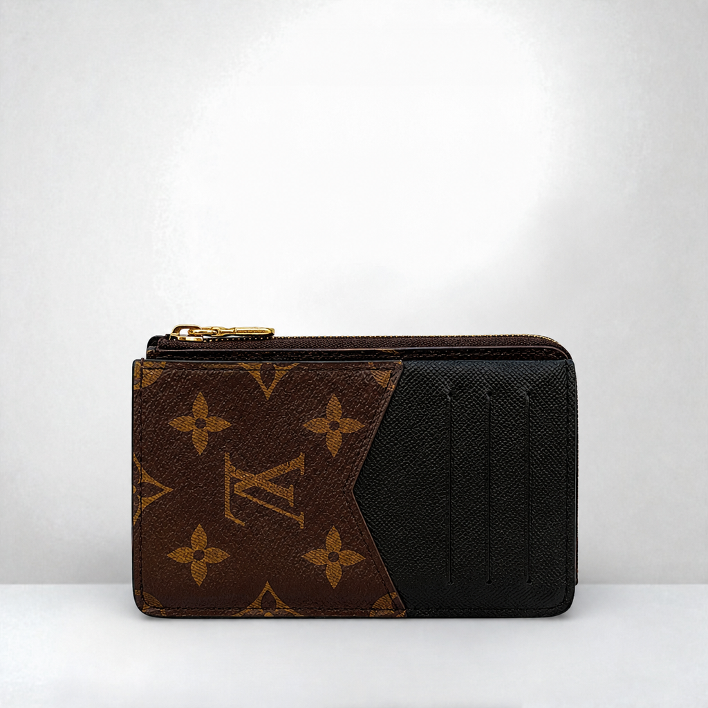 zip-around wallet in brown and black canvas, featuring gold-tone hardware, set against a plain light gray background.