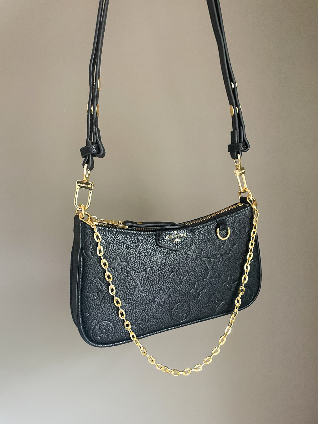 Black structured shoulder bag with durable grained texture and gold chain strap, versatile 3-way pouch