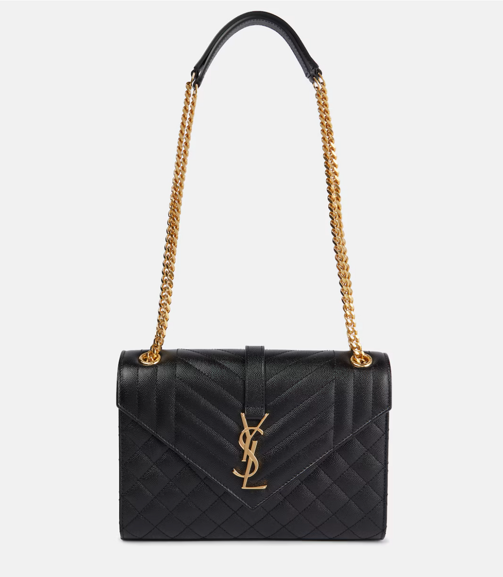 Black handbag with gold chain strap on a white background