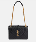 Black handbag with gold chain strap on a white background