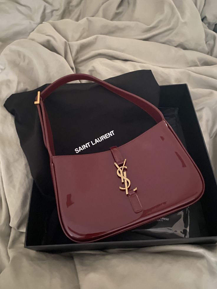 Burgundy patent leather hobo bag with gold hook closure, glossy 90s style shoulder bag