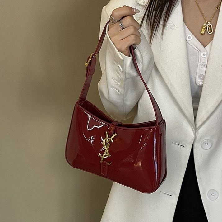 Woman styling a burgundy patent underarm bag with jeans, viral cherry red fashion aesthetic.