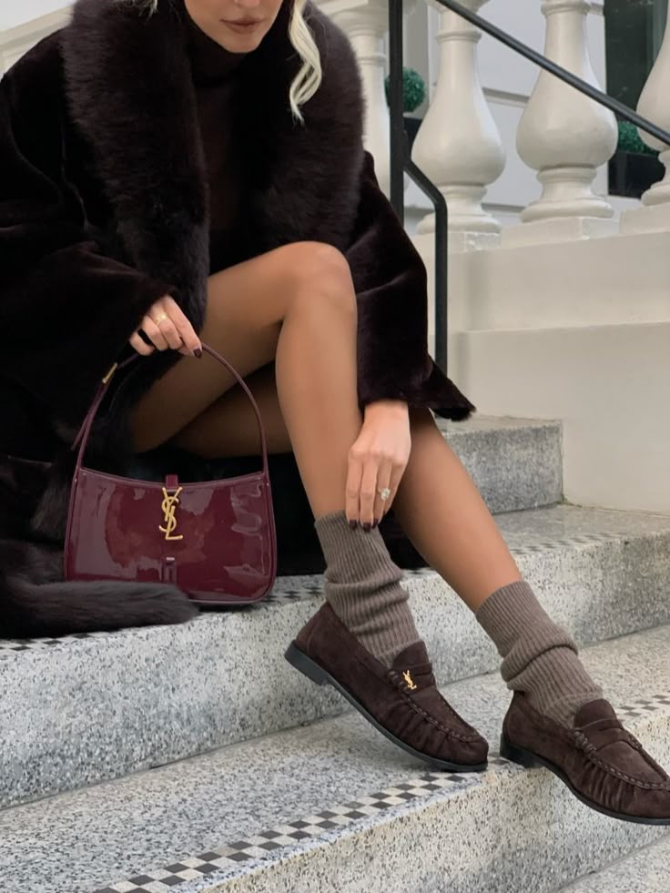 Woman styling a burgundy patent underarm bag with jeans, viral cherry red fashion aesthetic.