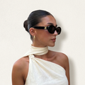 Woman wearing a white one-shoulder dress with a plain background