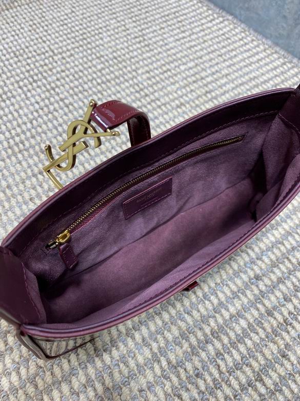 Close up of high shine burgundy patent leather texture and gold metal closure detail.