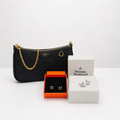 A black embossed leather shoulder bag with a gold chain strap and gold logo plate, displayed alongside a black Orvis box, a pair of gold cufflinks in an orange box, and a pair of silver cufflinks in a white box.