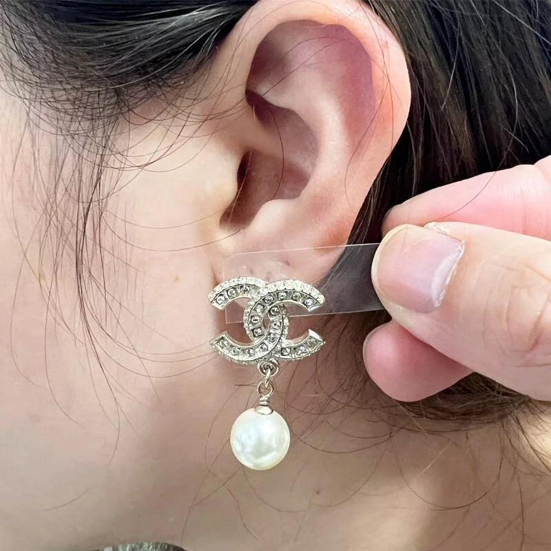 Woman wearing silver pearl earrings with crystal detail, clean girl aesthetic accessory for wedding guest