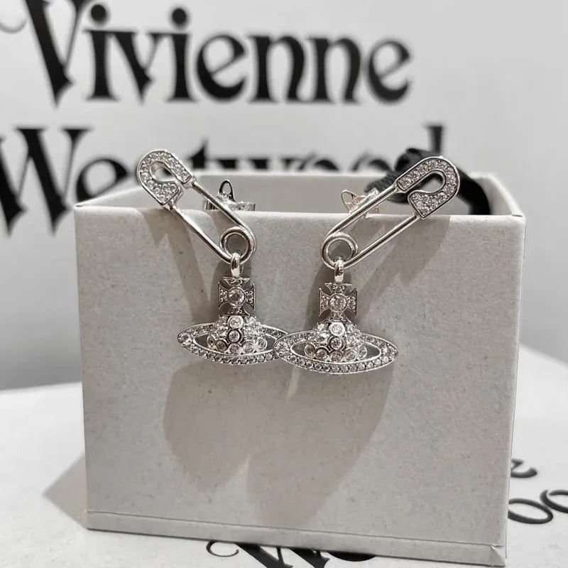 Silver safety pin earrings with hanging crystal planet orb charm, edgy punk style jewellery