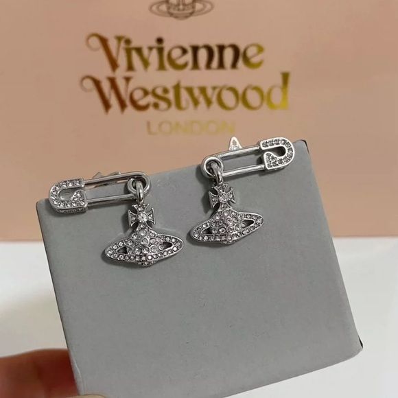 Silver safety pin earrings with hanging crystal planet orb charm, edgy punk style jewellery