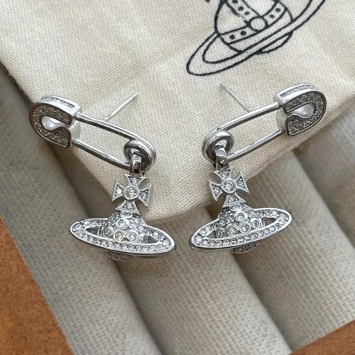 Silver safety pin earrings with hanging crystal planet orb charm, edgy punk style jewellery