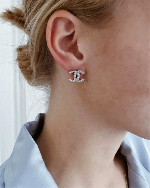 Woman wearing silver crystal stud earrings, clean girl aesthetic jewellery styling for everyday elegance.