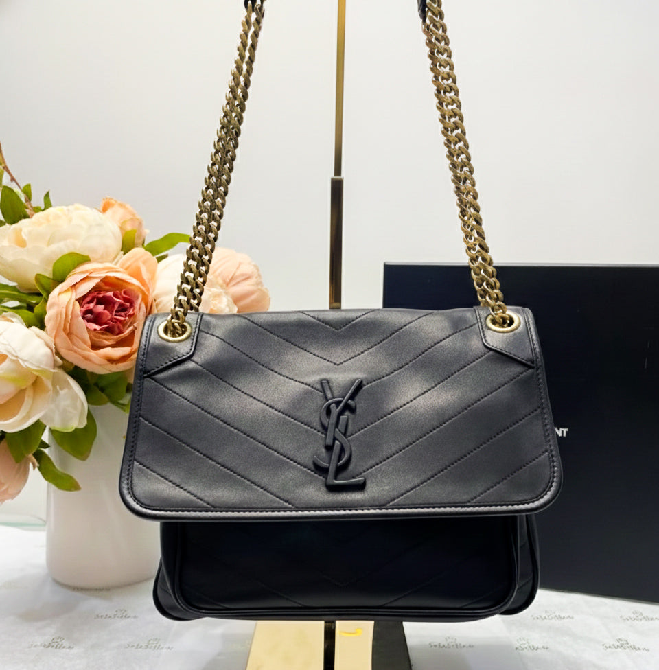 Medium black smooth leather shoulder bag with chevron quilting and antique gold chain strap. Minimalist rock chic style.