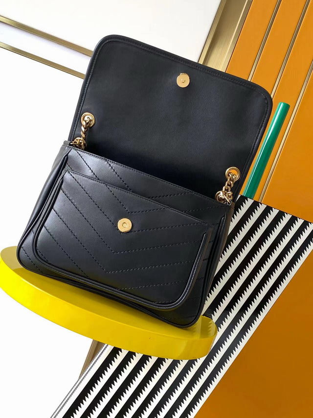 Medium black smooth leather shoulder bag with chevron quilting and antique gold chain strap. Minimalist rock chic style.