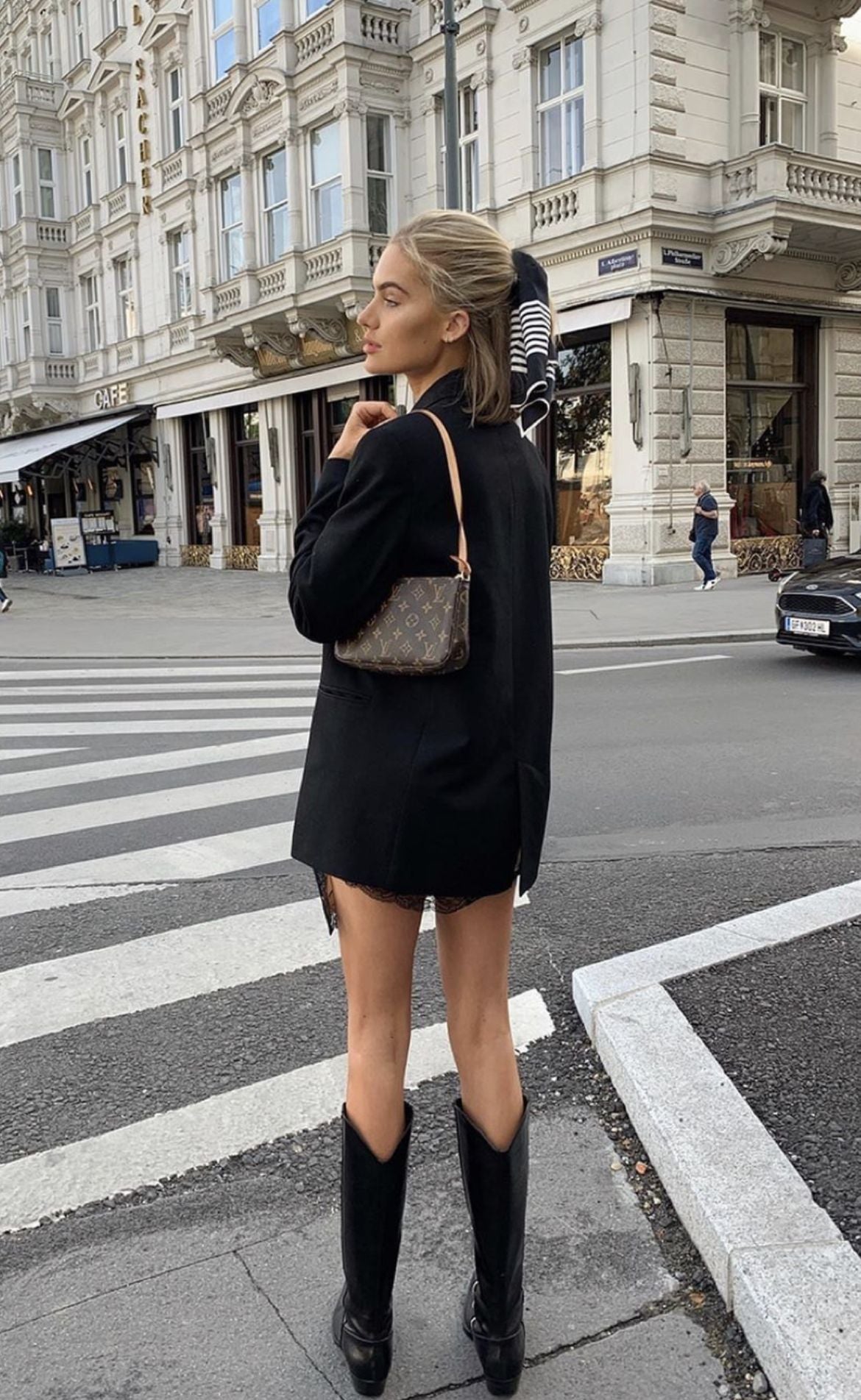 Woman wearing brown checkerboard mini bag with black trench coat, old money aesthetic fashion