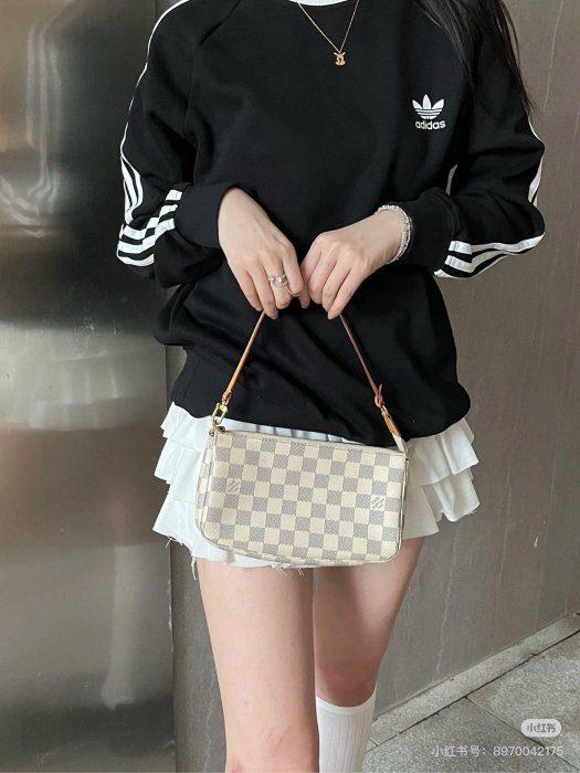 White checkerboard cosmetic pouch styled with cream knitwear, clean girl aesthetic accessories